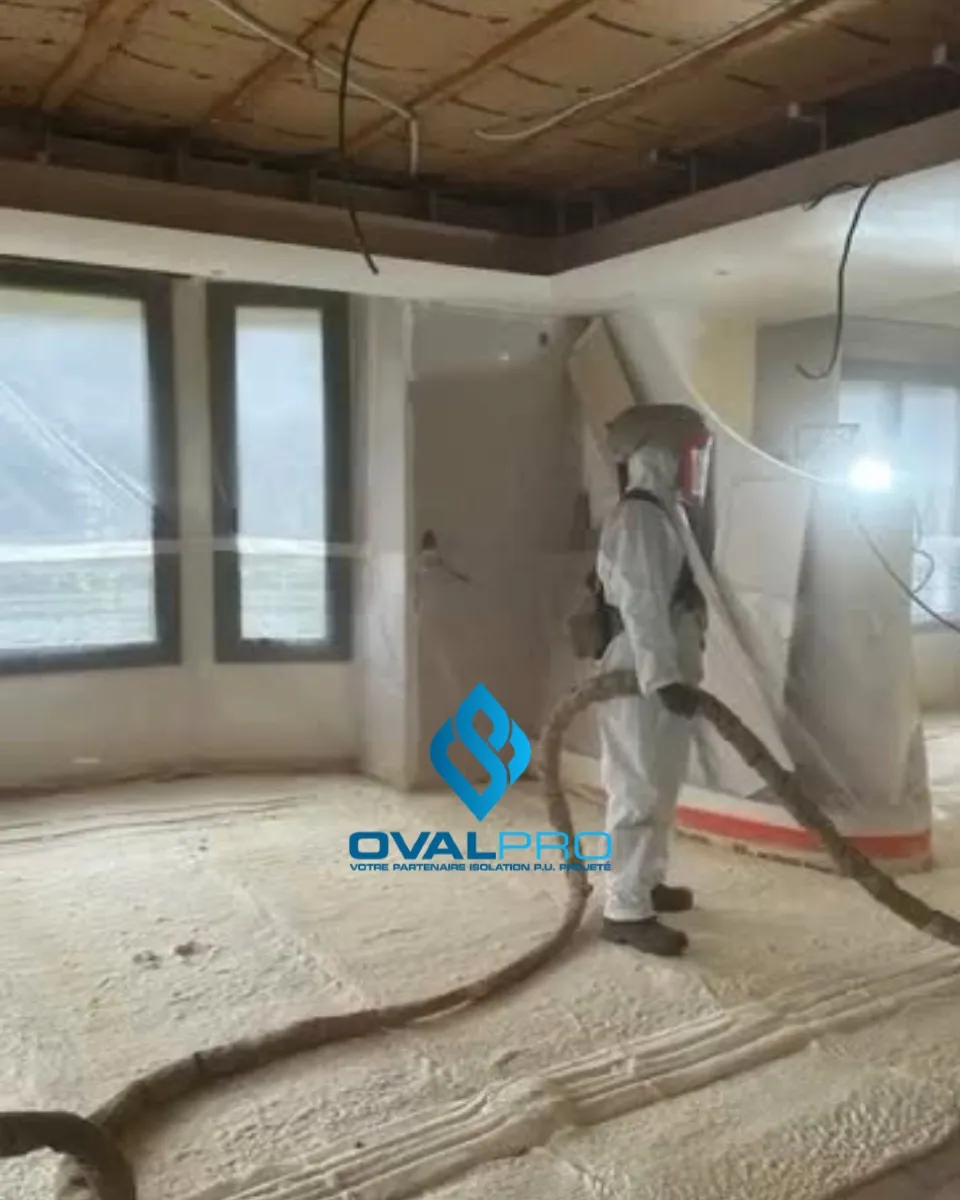 Chantier isolation mousse projetée — technicien en action